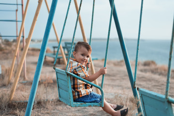 Child on a swing near the sea