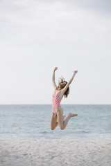 Young woman jumping on the beach