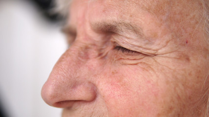 Naklejka premium Close up of old thoughtful woman eye