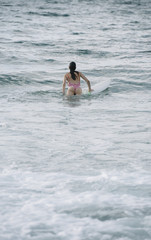 Young woman surfing the wave on his surfboard