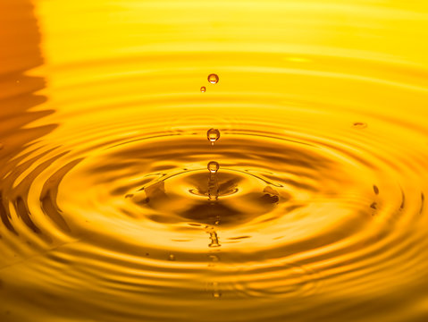 Close Up Of A Drop Oil On A Yellow Background