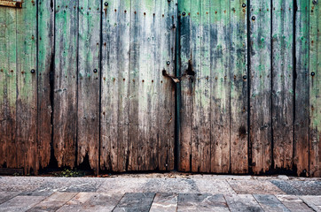 Old weathered wooden closed door, grungy background.