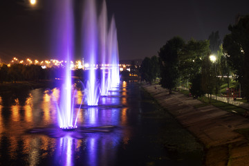 Night embankment with colorful fountains