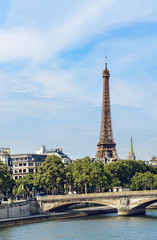 Fototapeta na wymiar Eiffel tower in Paris over bridge of Invalids-arch over the Seine, located between the bridges of Alma and Alexander III