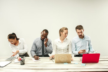 Young african and caucasian men and women sitting at office and working on laptops. The business,...