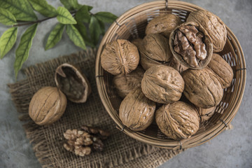 Walnuts in wooden bowl. Whole walnut on table