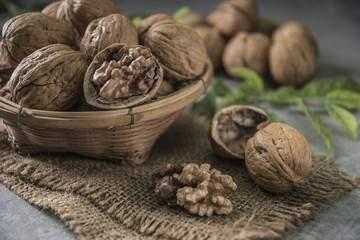 Walnuts in wooden bowl. Whole walnut on table