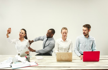 Young african and caucasian men and women sitting at office and working on laptops. The business,...