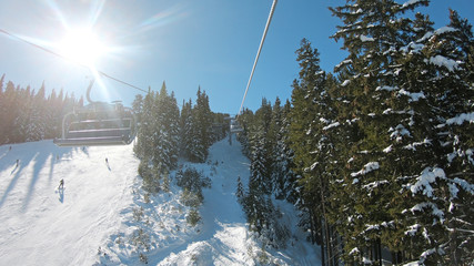 Snowboarder POV getting transported uphill by ski lift