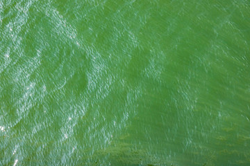 Fototapeta na wymiar Green water with sunbeams in. Background
