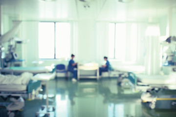 Two nurses on the day shift in the intensive care unit, unfocused background