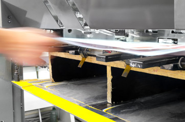 offset machine press print run at table, sheet pull of finishing unit. Poster printing