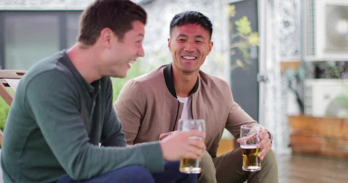 Male friends drinking beer in an outdoor bar