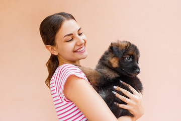 Beautiful woman holding and looking into black puppy's eyes