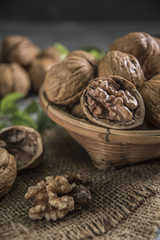 Walnuts in wooden bowl. Whole walnut on table