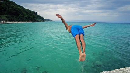 Attractive man jumping into water © zefart