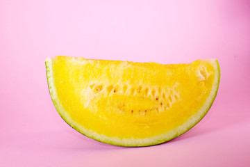 Yellow melon watermelon slice on pink background.