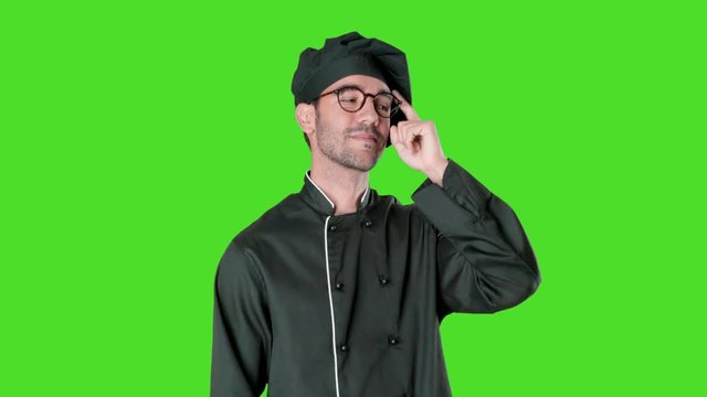 Happy young chef with a gesture of having an idea against green background