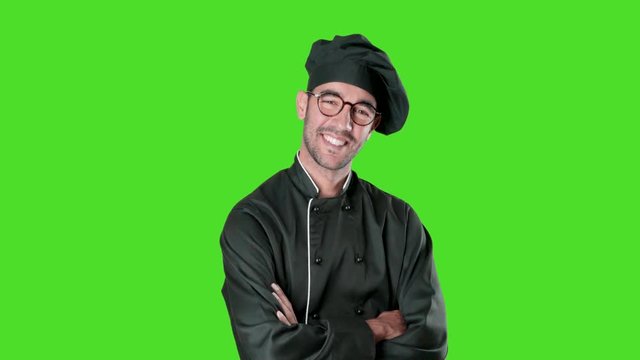 Happy young chef with a confidence gesture against green background