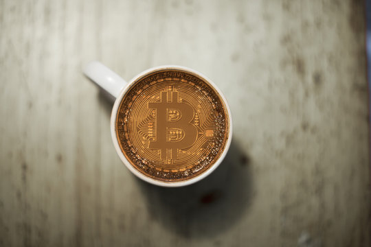 a cup of coffee payed by crypto currency bitcoin