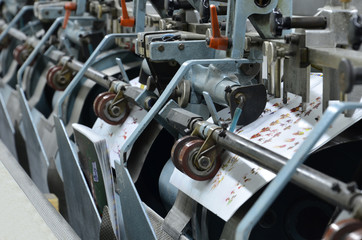 magazine binding process after offset print. Close-up of the conveying process of a full-automatic...