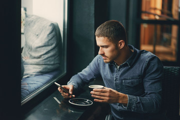 man using phone inside a restaurant