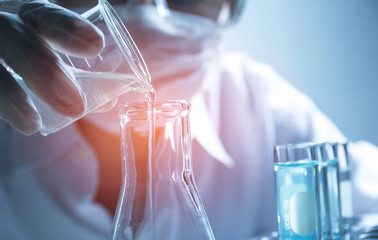 Researcher with glass laboratory chemical test tubes with liquid for analytical , medical,...