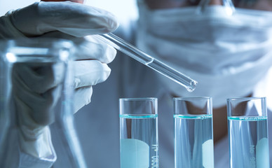 Researcher with glass laboratory chemical test tubes with liquid for analytical , medical,...