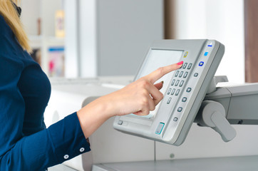 One finger pressing a print button on large printer ploter. Injet printing concept.