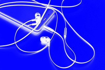 white headphones for listening music on blue background