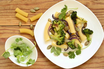 Pasta with roasted broccoli, purple onions and pumpkin seeds