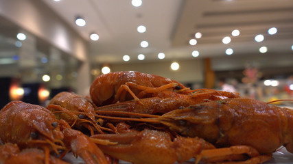 Point of view. The waiter carries a plate of crayfish in the restaurant's hall. Concept of luxury recreation and eating at an expensive resort.