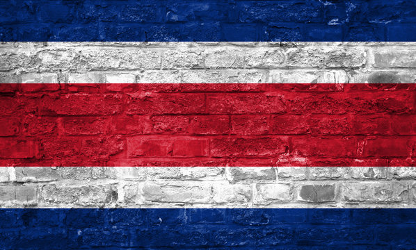 Flag of Costa Rica over an old brick wall background, surface