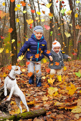 Funny children on a walk with a dog in the autumn forest
