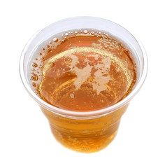 Plastic glass with a sparkling yellow drink, white isolated