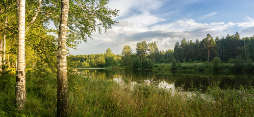 Панорама летнего вечернего пейзажа на Уральском озере с березами на берегу, Россия, август