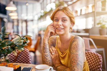 beautiful tattooed ginger girl in cafe