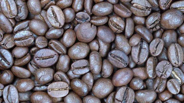 Fried coffee beans background, close up, rotation loopable 4k top view. Food  background. Gastronomy concept, organic food. Macro coffee beans