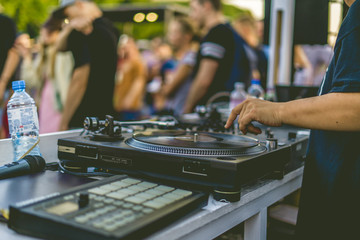 dj hands play music vibes on a summer beach party using a vintage deck setup turntable