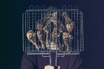 man holds cooked fried meat barbeque grill isolated on dark background