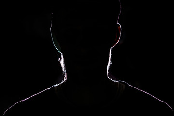 lighten portrait silhouette of a human head in the dark  background