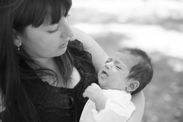 Adorable beautiful newborn baby in the park with mother