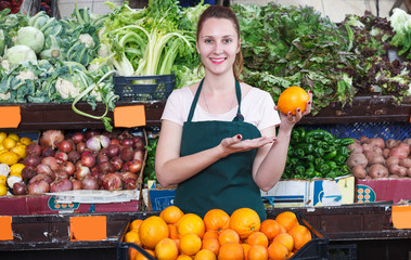 seller woman is demonstraiting oranges