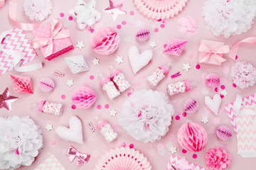 Pink and white Paper Decorations, pom-pom, candy, hearts, gifts, confetti for Baby party. Birthday concept.  Flat lay, top view