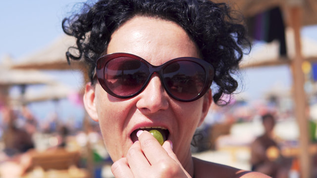 Woman eating grapes on beach