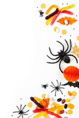 Obraz na płótnie Canvas Halloween holiday background with colorful candy, bats, spiders, pumpkins and decorations. Flat lay. View from above