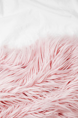 Bedding with a pink fluffy fur plaid. Copy space. Flat lay, top view