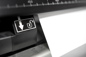 Detail of Large Plotter Digital Printer Printing Poster. Focus on paper release button
