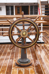 timón de madera situado en la cubierta de madrea en un barco de pasajeros © tingitania