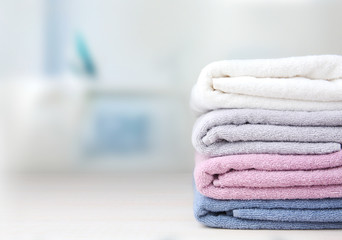 Colorful folded towels stack on table empty space. - obrazy, fototapety, plakaty